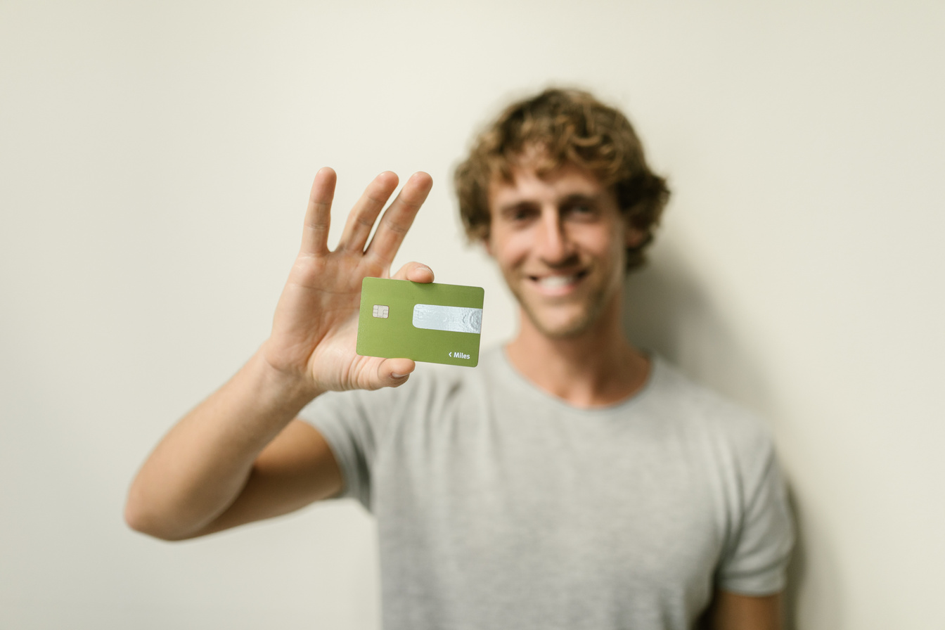 Man Smiling while Holding a Credit Card